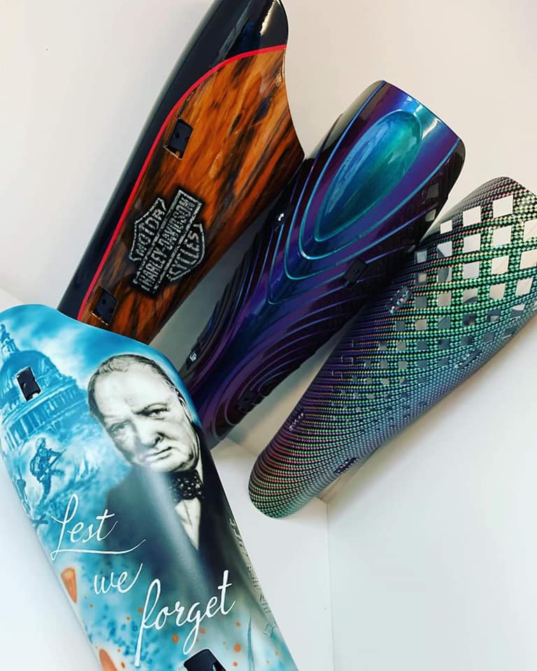 Trio of prosthetic leg covers in a range of designs including one of Winston Churchill and the quote Lest We Forget